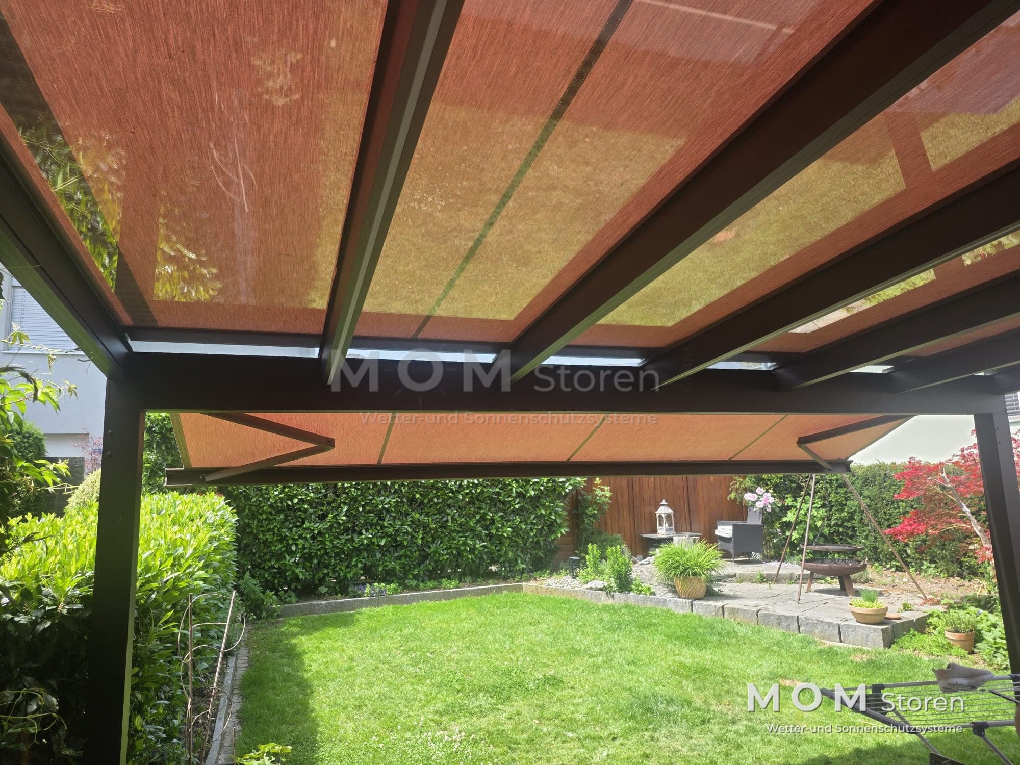 Fabric roof with dark beams beside a garden