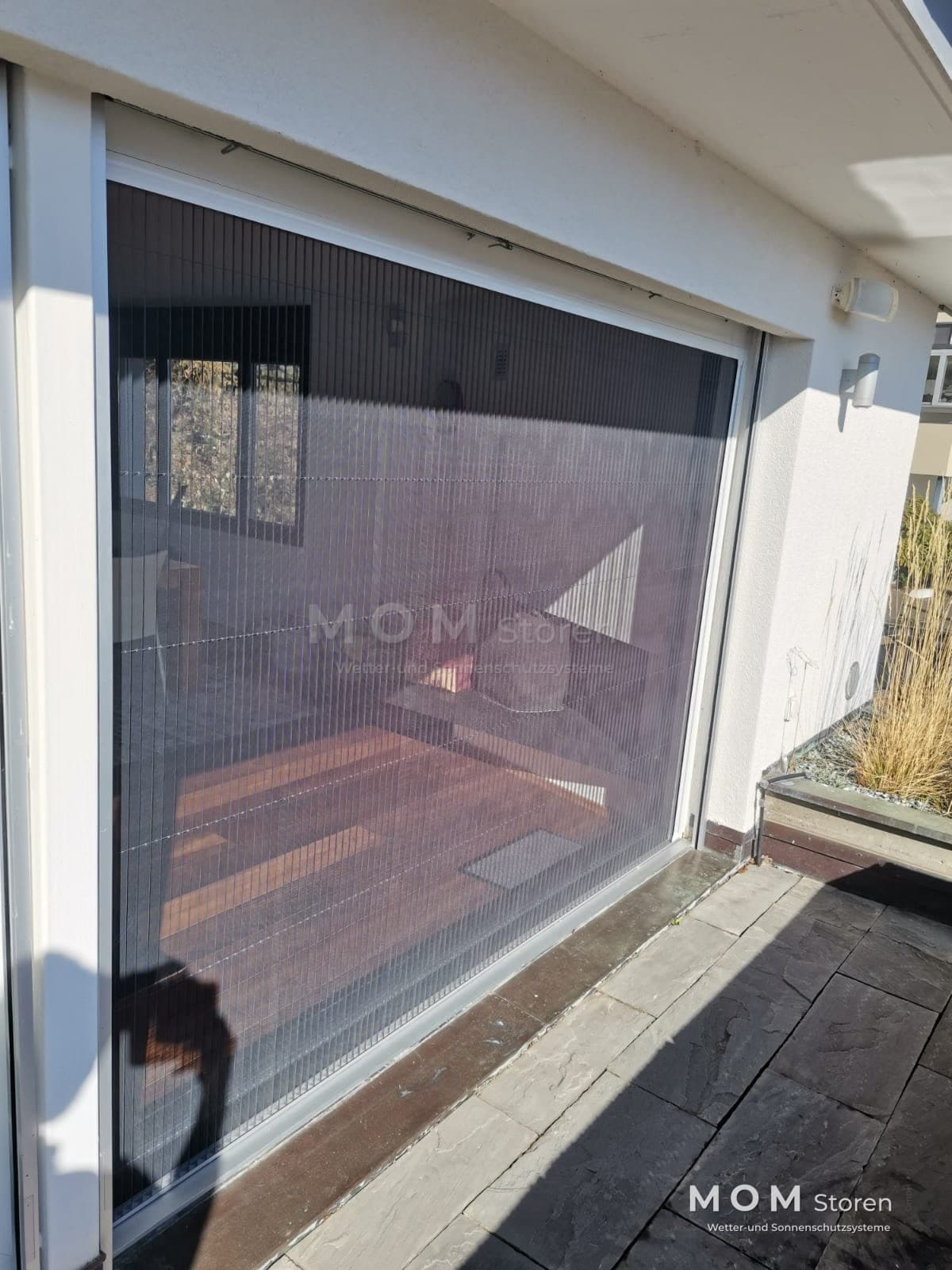 Textile screen in front of light-framed glazing
