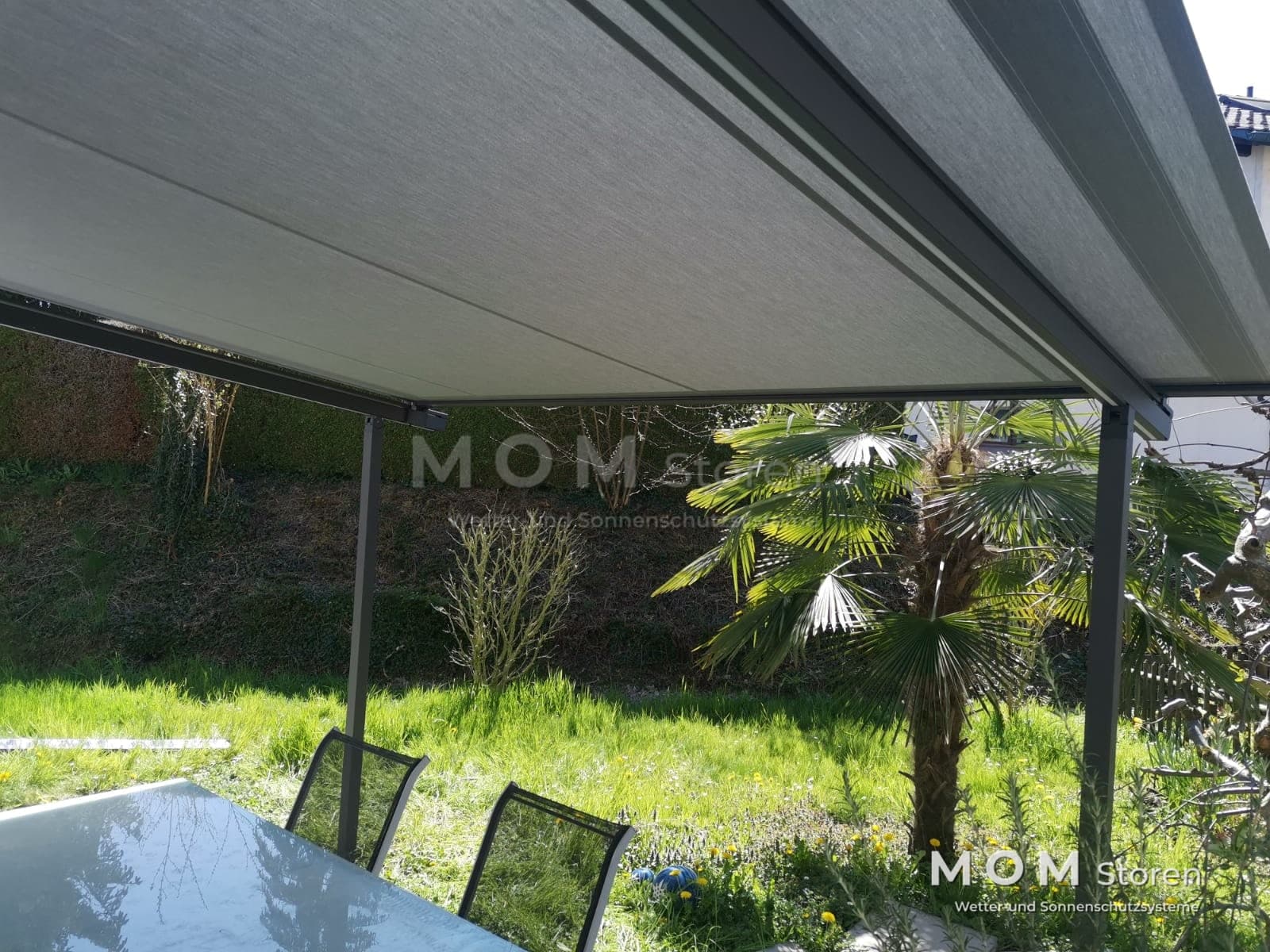 Folding-arm awning over a table by the garden