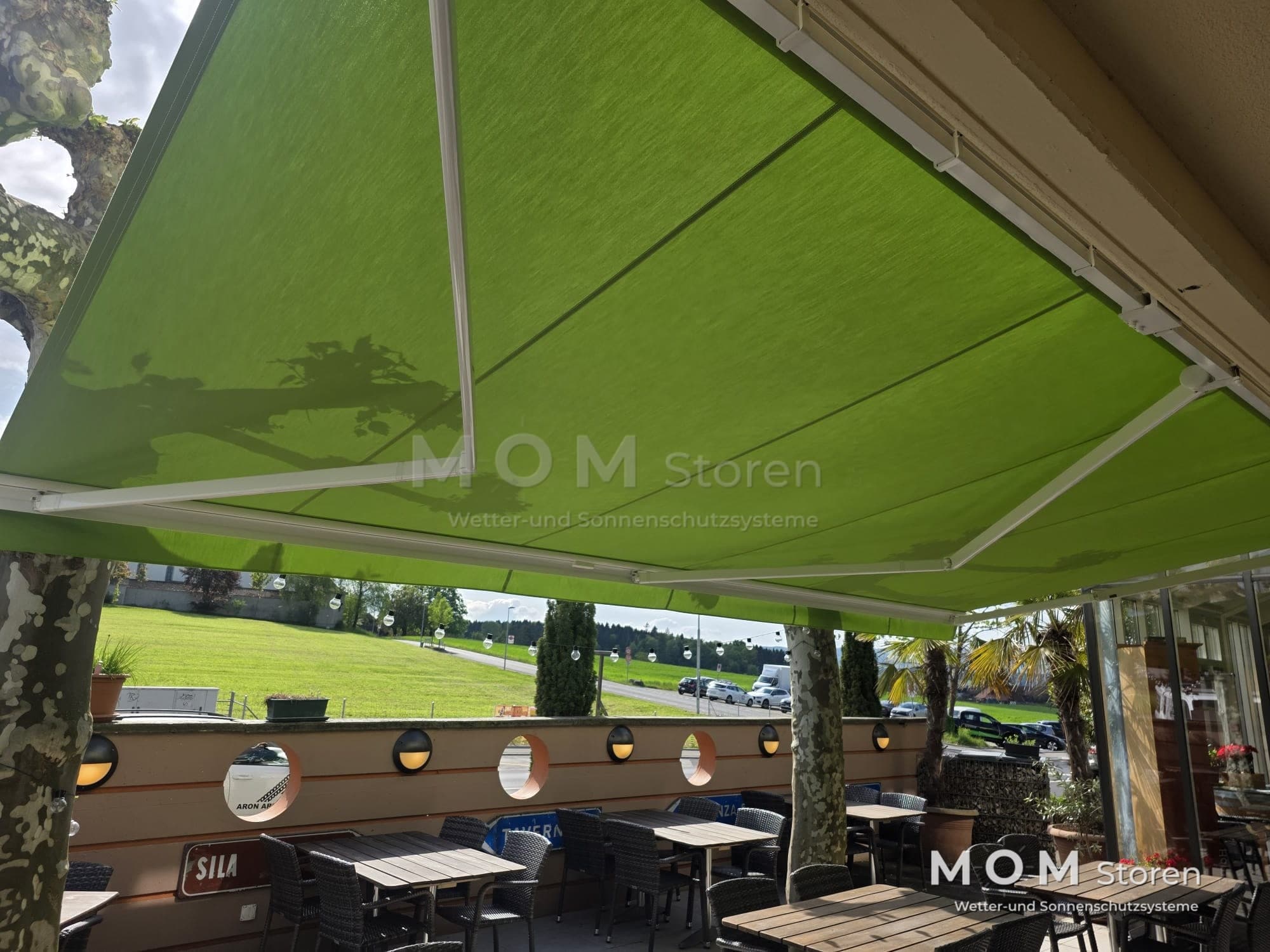 Green awning over an outdoor seating area