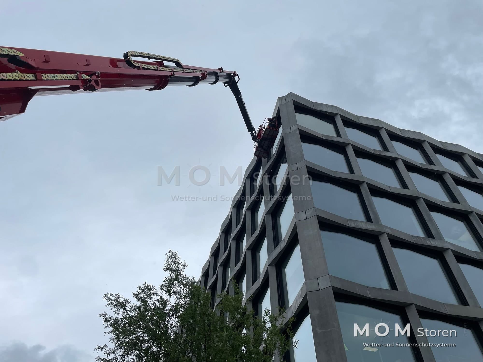 Façade installation with lifting equipment at a commercial building